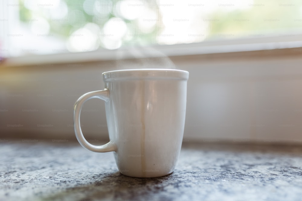 Una taza de café blanca encima de un mostrador