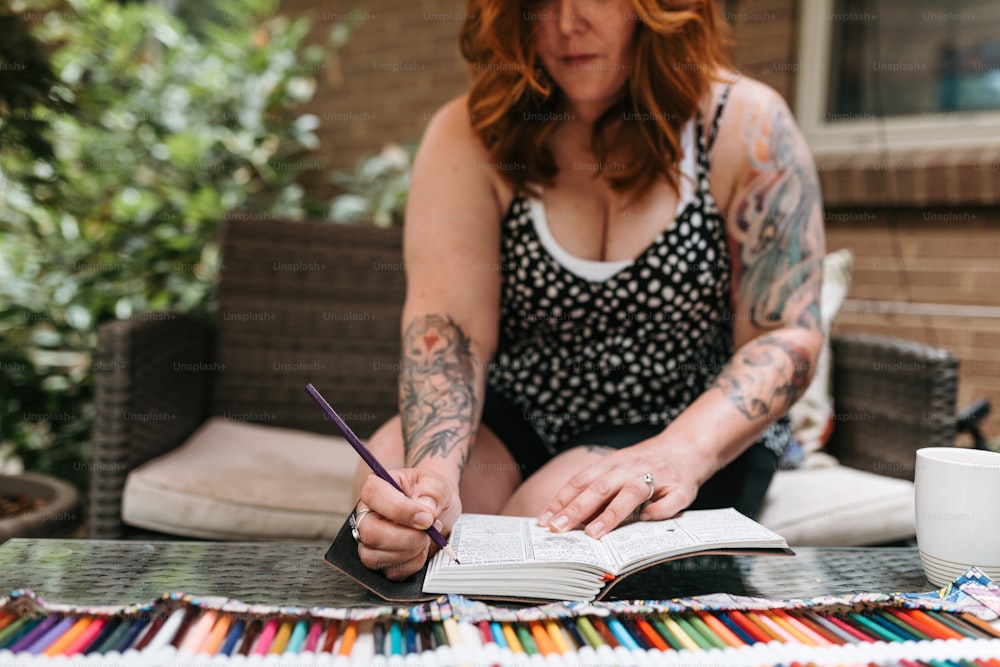 una donna seduta a un tavolo con un libro e una penna