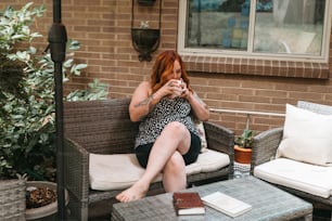 a woman sitting on a couch in front of a brick building