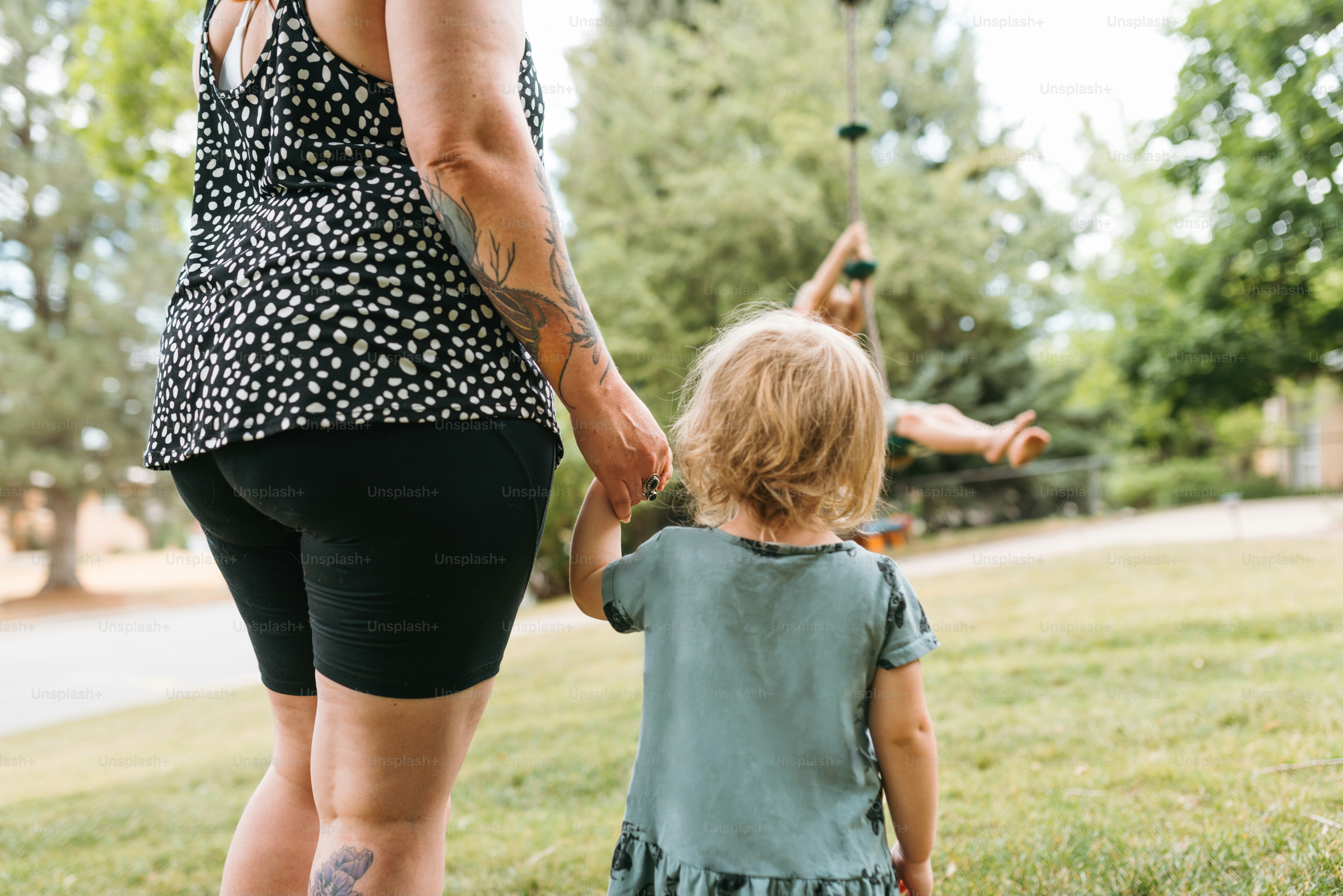 a woman holding the hand of a little girl