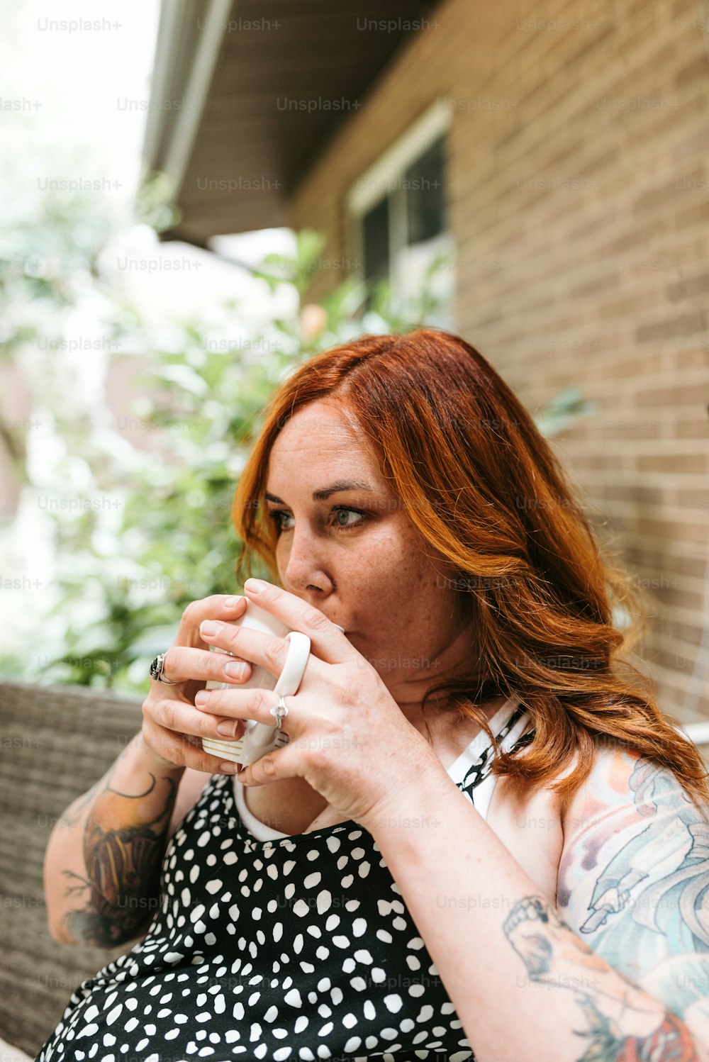 Eine Frau, die auf einer Bank sitzt und aus einer Tasse trinkt