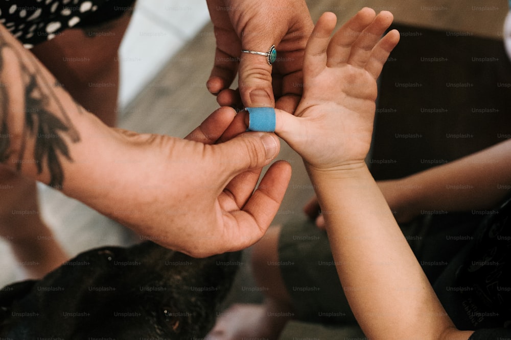 a group of people putting a ring on a child's finger