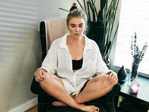 a woman sitting in a chair with her legs crossed