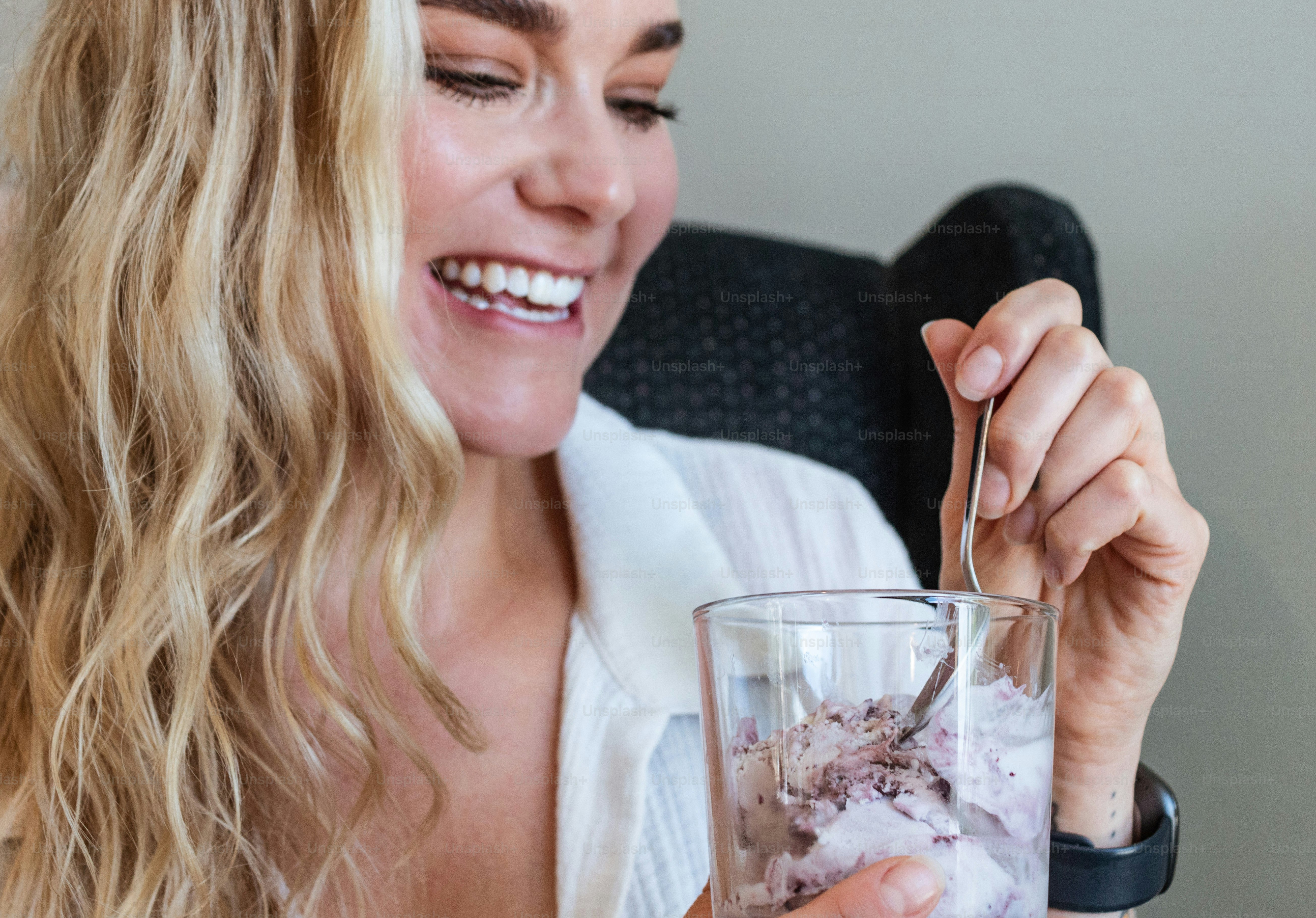 a woman sitting in a chair holding a glass of ice cream