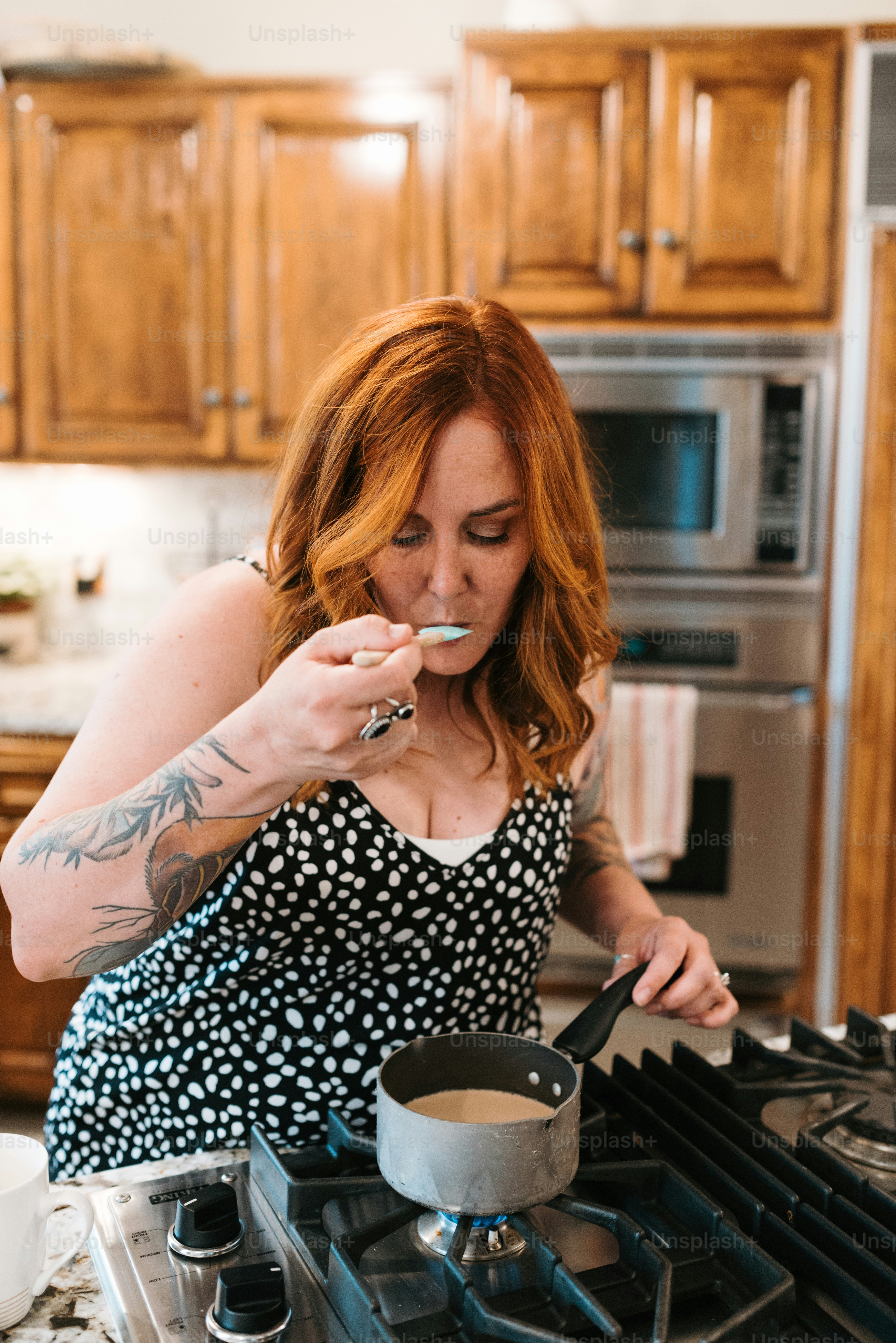 Une femme en robe noire et blanche cuisine sur un poêle