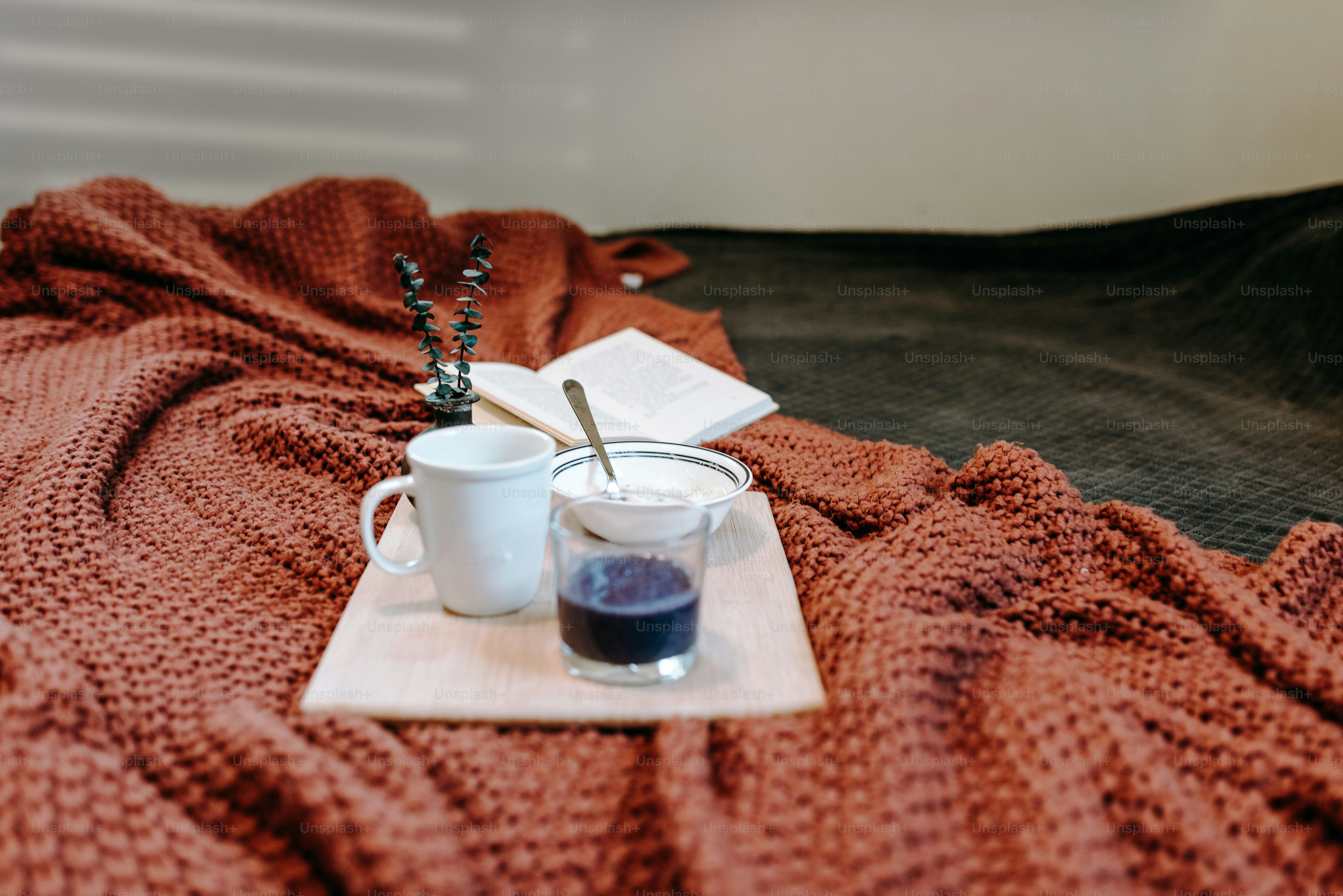 a cup of coffee and a book on a bed