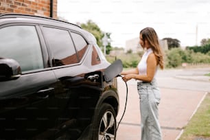 a woman is pumping gas into her car