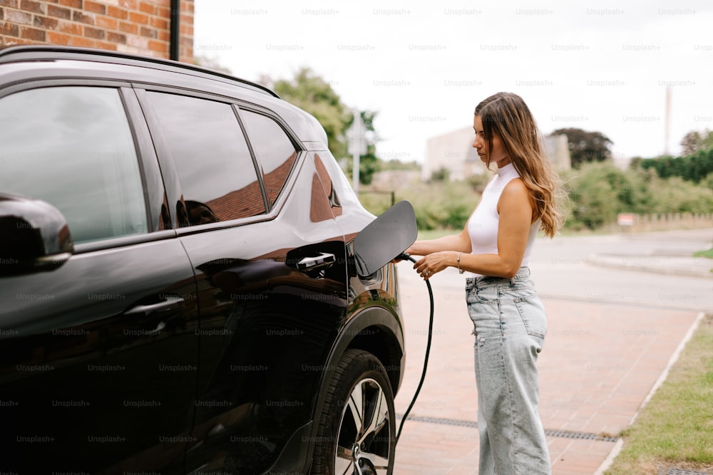 a woman is pumping gas into her car