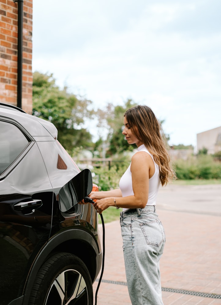 Une femme recharge sa voiture électrique