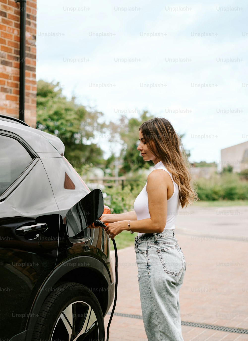 a woman is pumping gas into her car