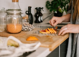a woman cutting up some fruit on a cutting board