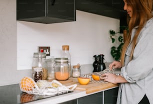 a woman standing in a kitchen preparing food