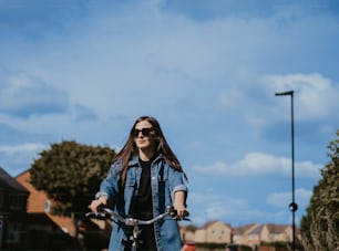 uma mulher andando de bicicleta por uma rua