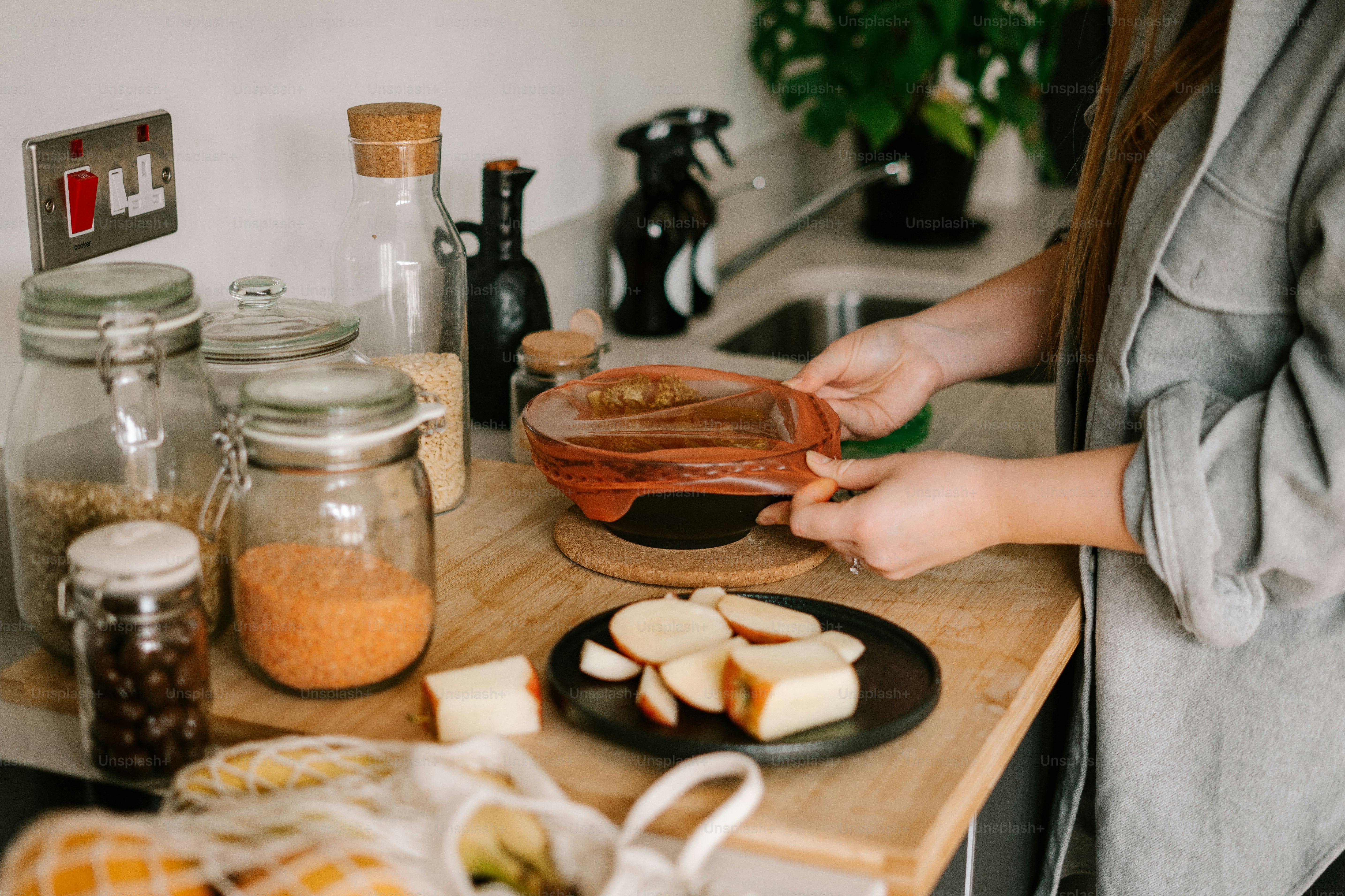 a woman in a gray jacket is making food on a counter