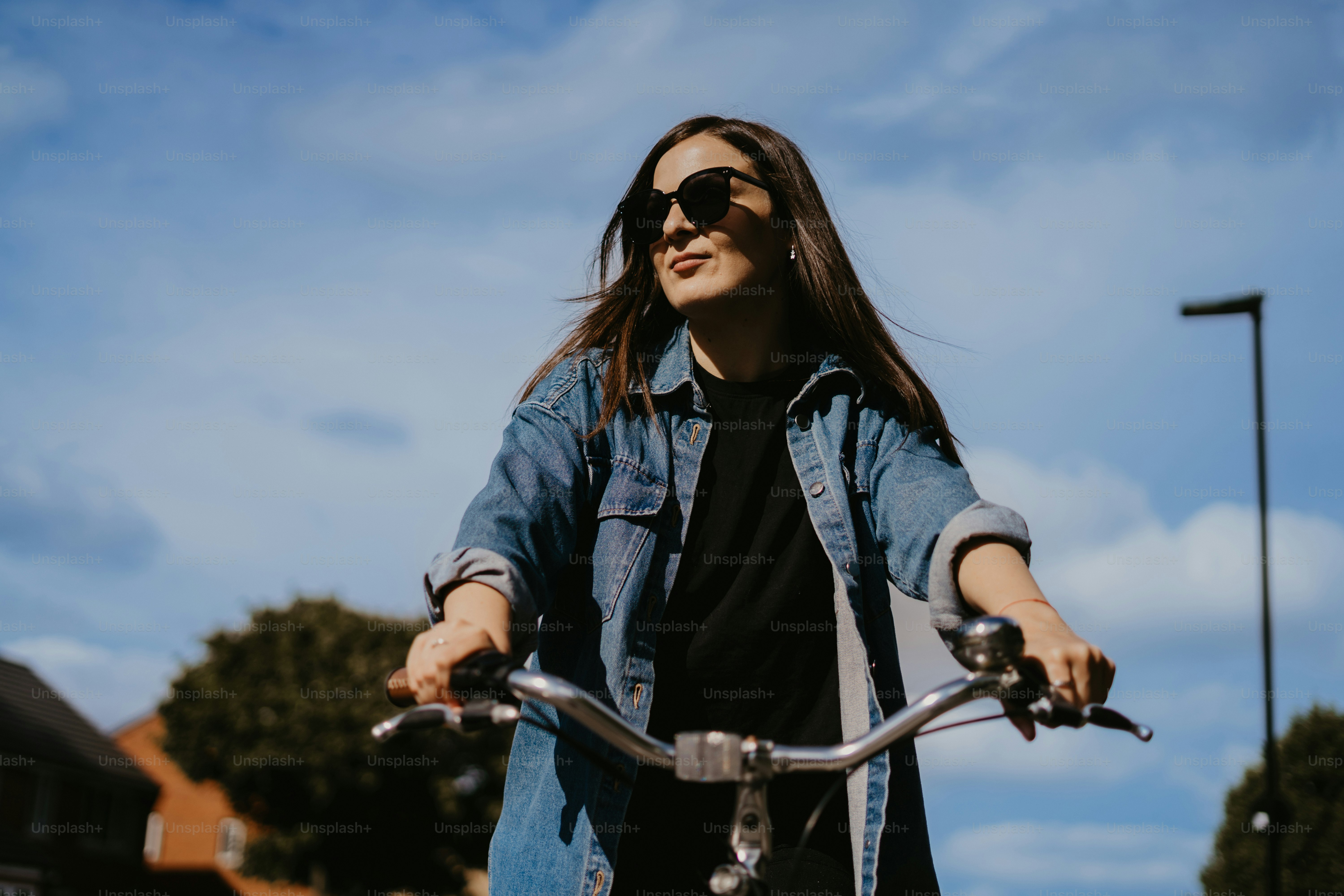 a woman riding a bike down a street