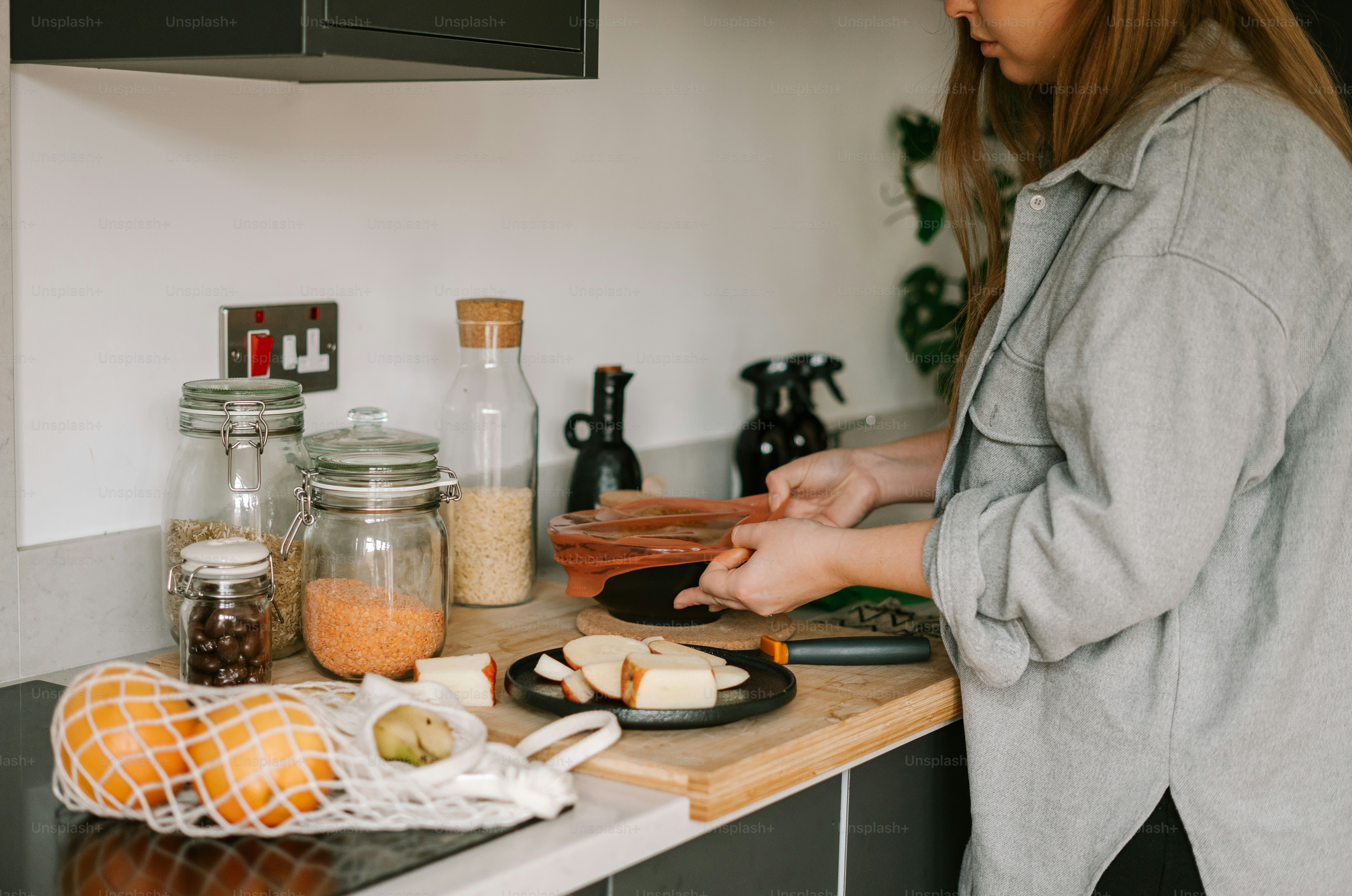 a woman standing in a kitchen preparing food