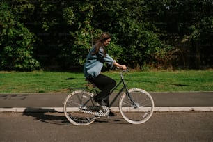 a woman riding a bike down a street