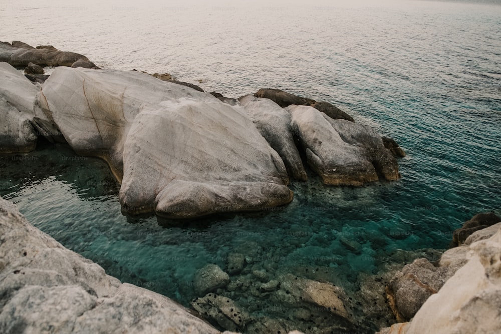 a body of water next to a rocky shore