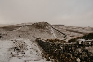 ein schneebedeckter Berg mit einer Steinmauer