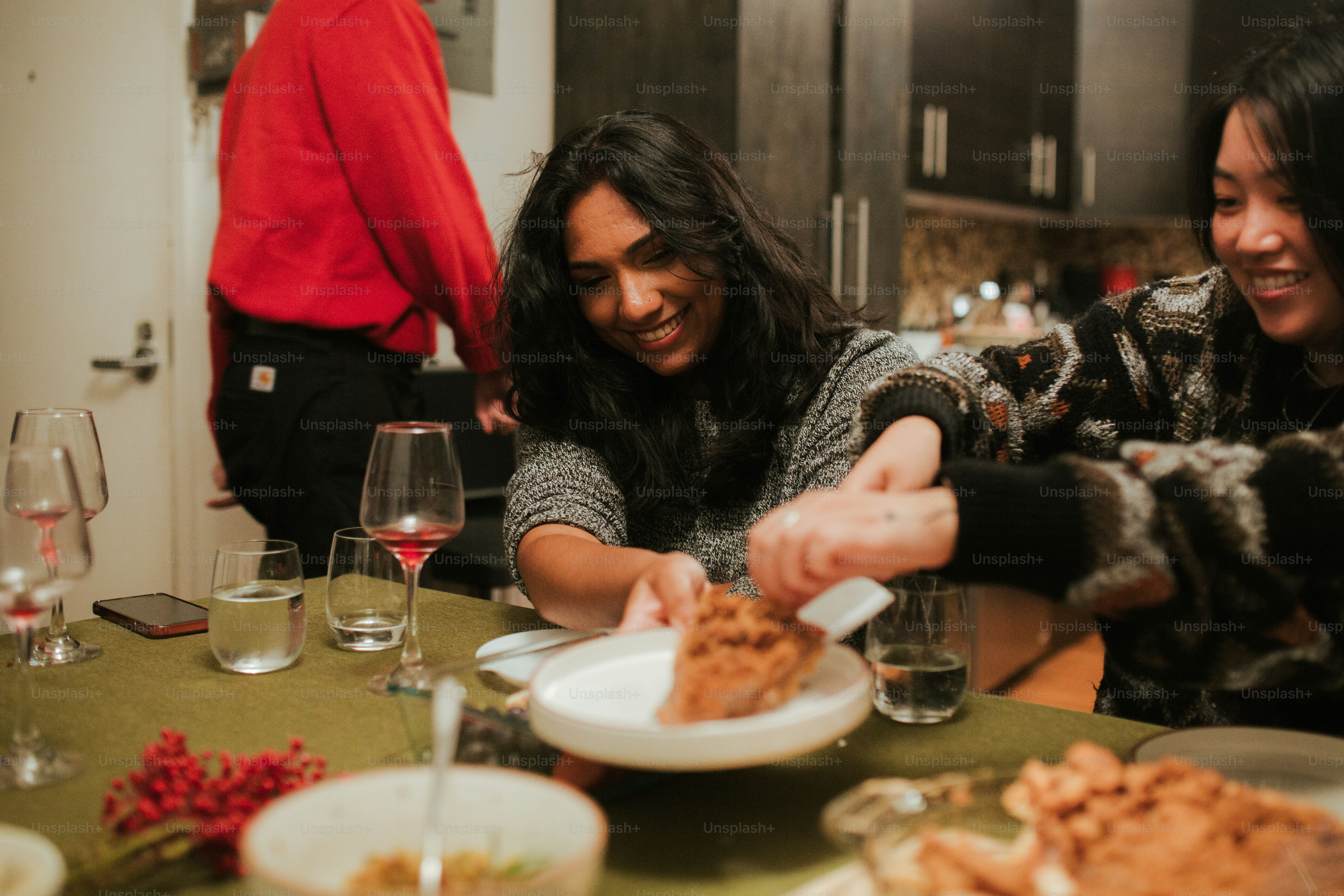 a couple of women sitting at a table with plates of food