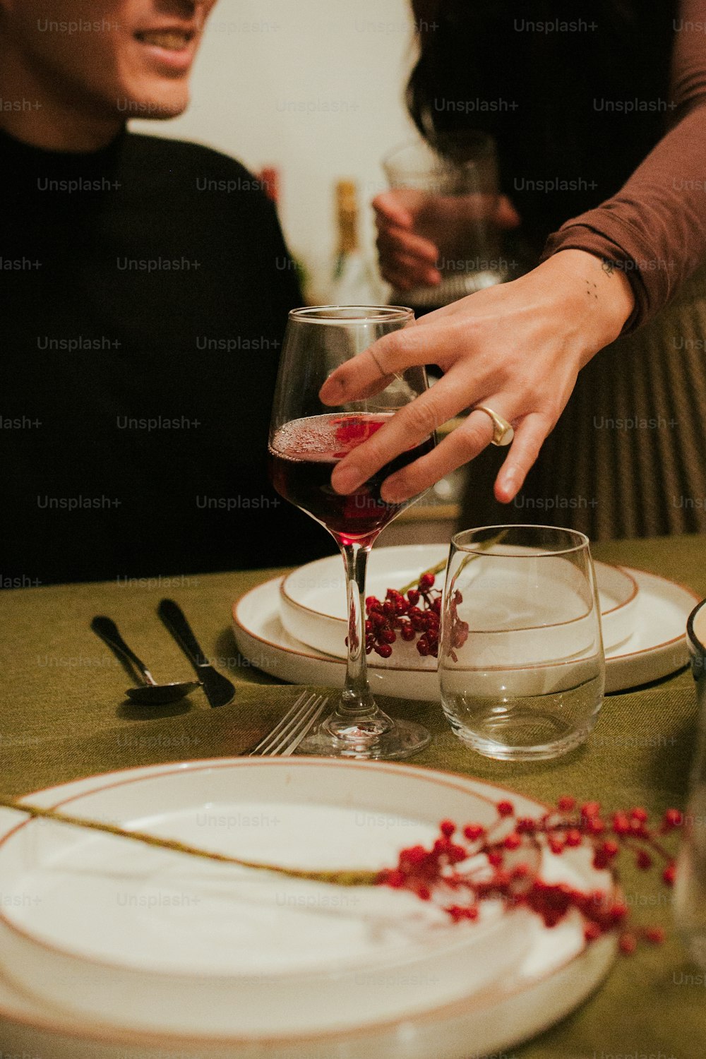 한 남자와 한 여자가 와인 한 잔과 함께 테이블에 앉아 있다