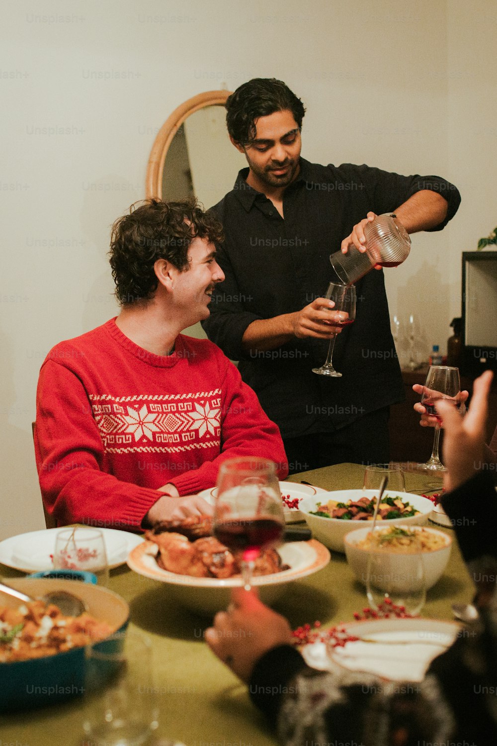 a group of people sitting around a table with plates of food