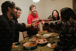 um grupo de pessoas em pé ao redor de uma mesa com comida