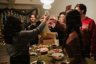 eine Gruppe von Menschen, die um einen Tisch stehen und Wein trinken