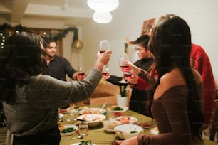 a group of people standing around a table holding wine glasses