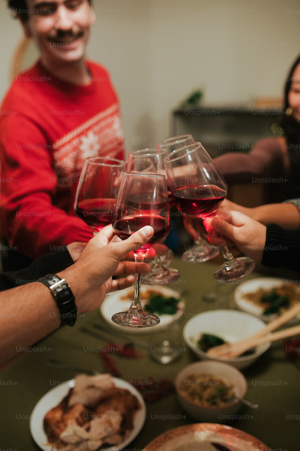 un groupe de personnes assises autour d’une table avec des verres à vin