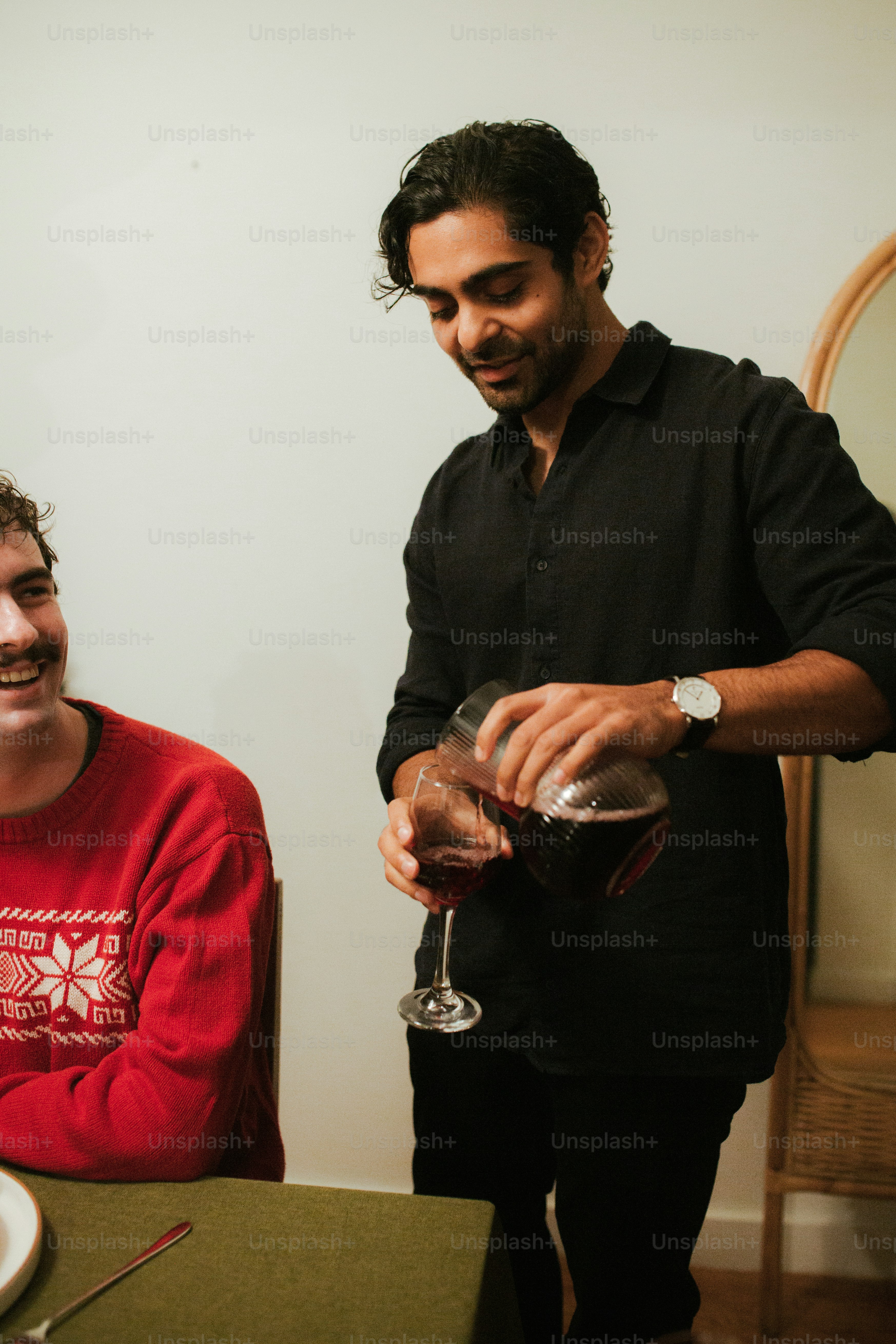 Un homme versant un verre de vin à un autre homme