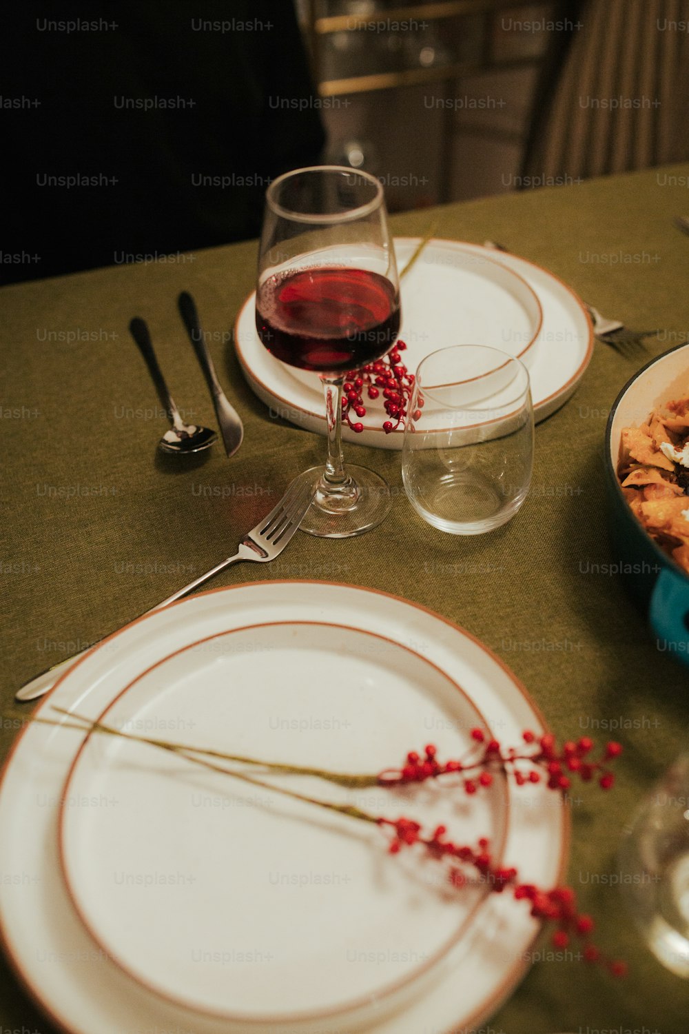 a table topped with plates of food and a glass of wine