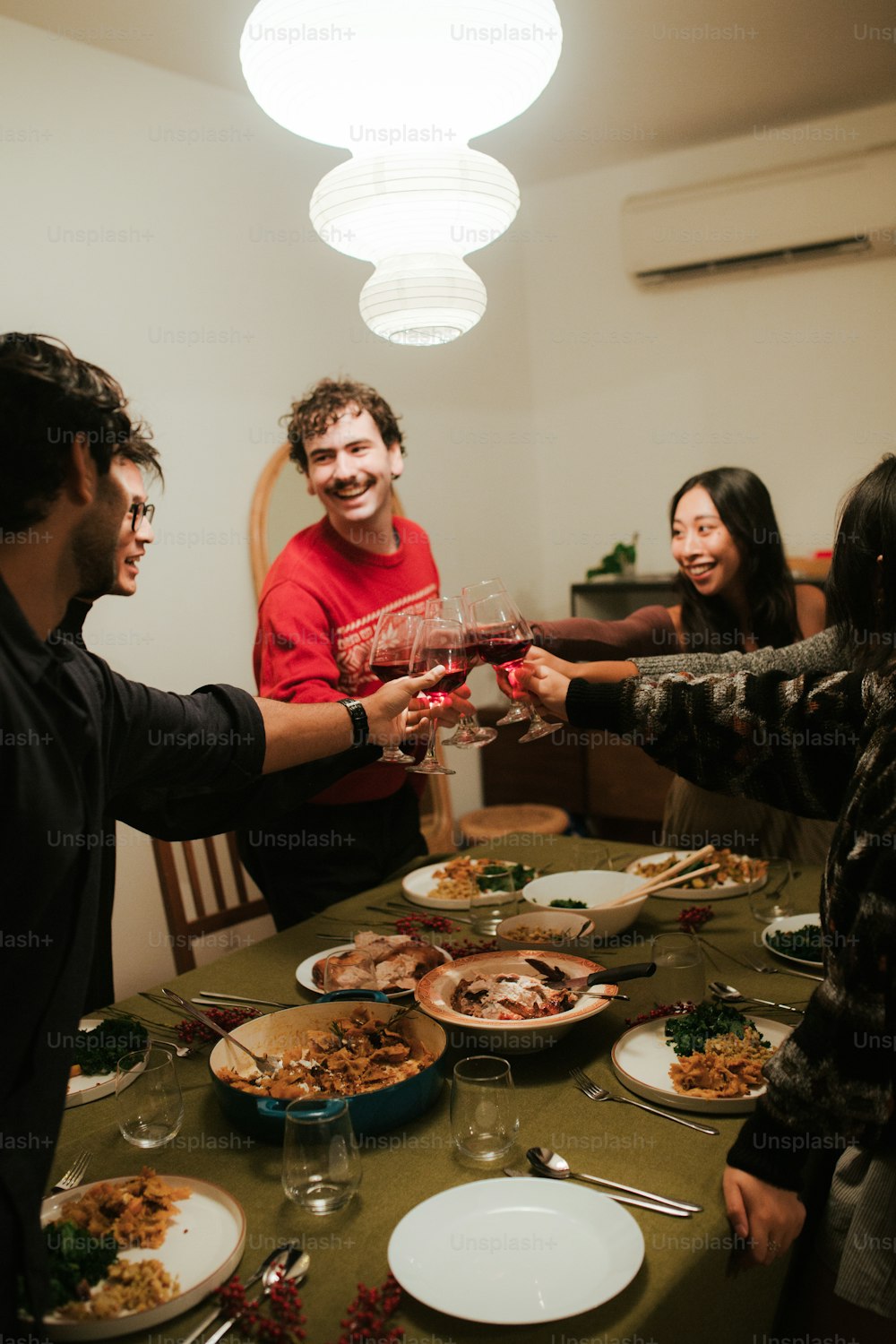 a group of people standing around a table with plates of food