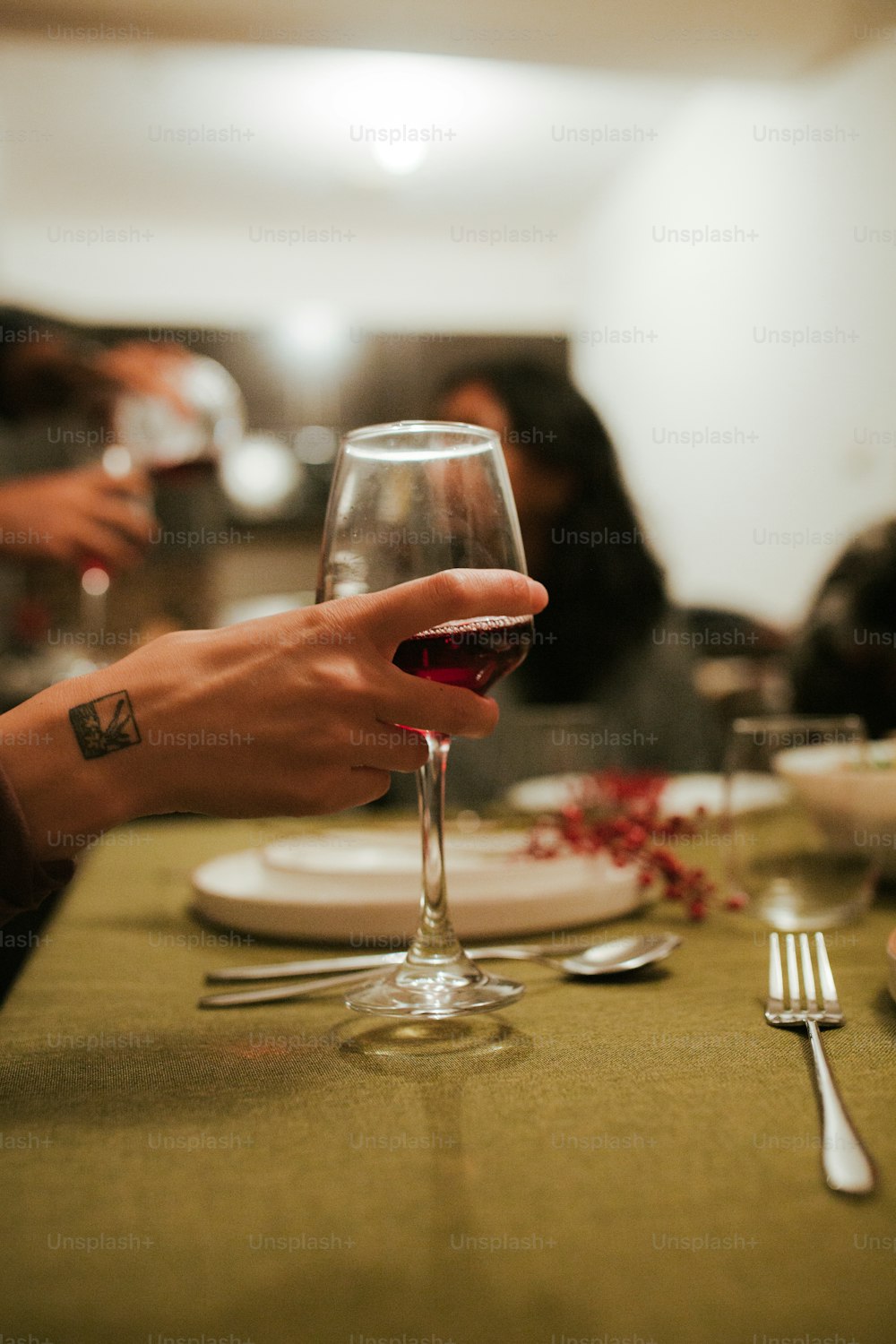 테이블에서 와인 한 잔을 들고 있는 사람