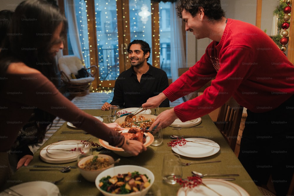 Eine Gruppe von Menschen, die um einen Tisch mit Tellern mit Essen sitzen