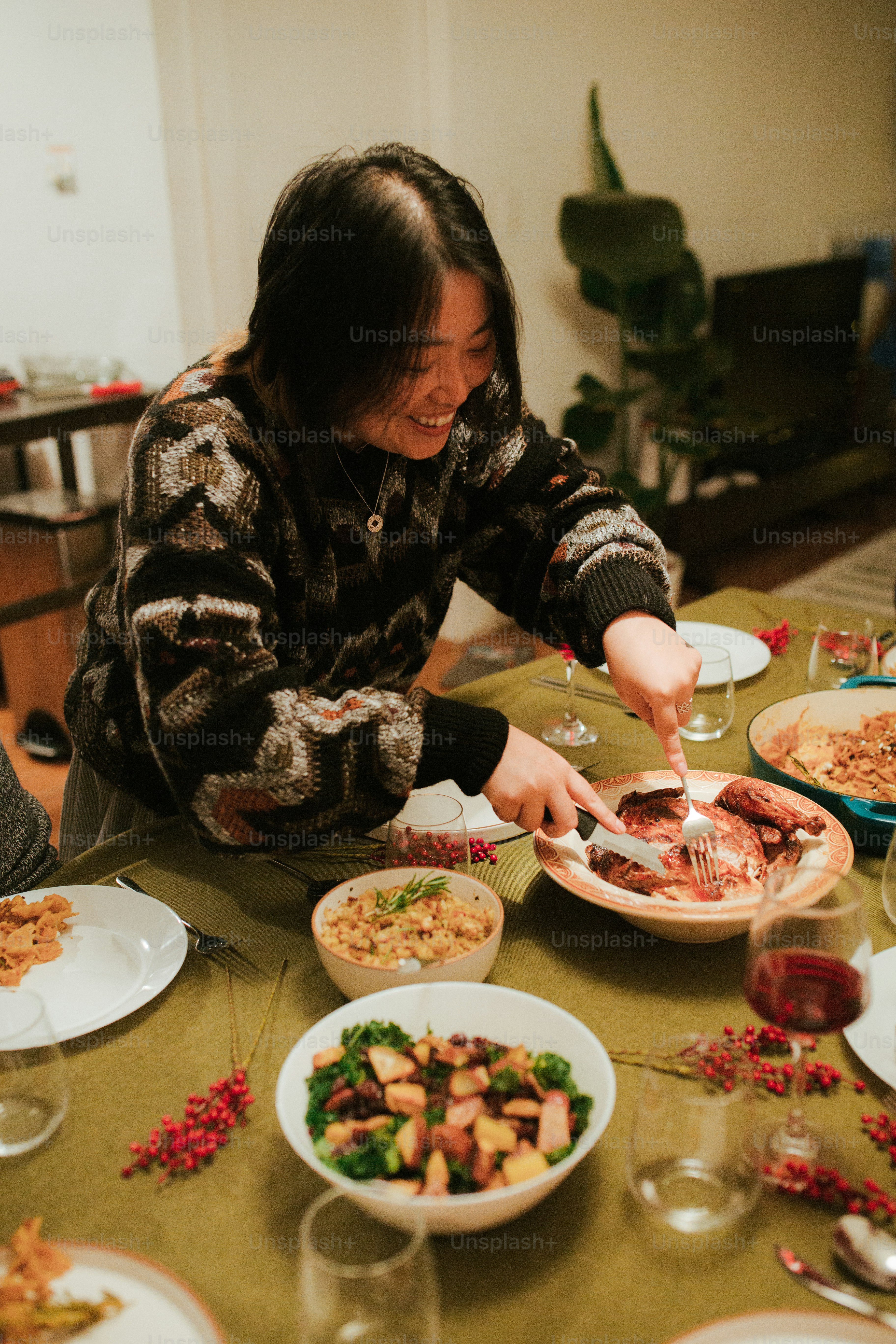 A woman sitting at a table with plates of food photo – Dinner party ...