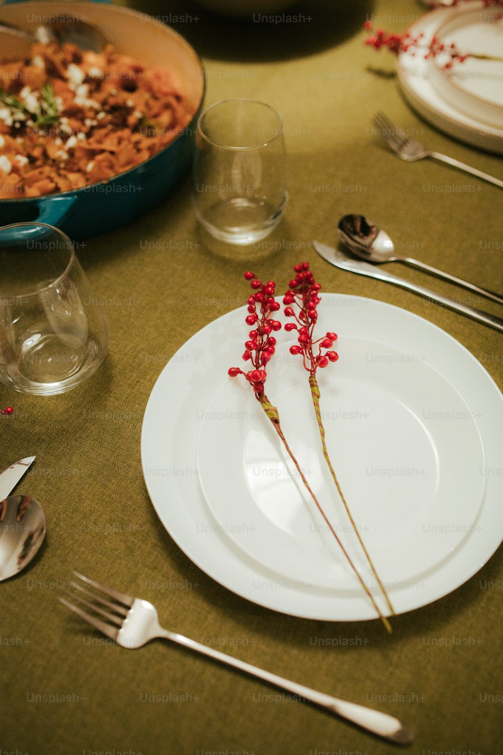 ein weißer Teller mit roten Blumen auf einem Tisch