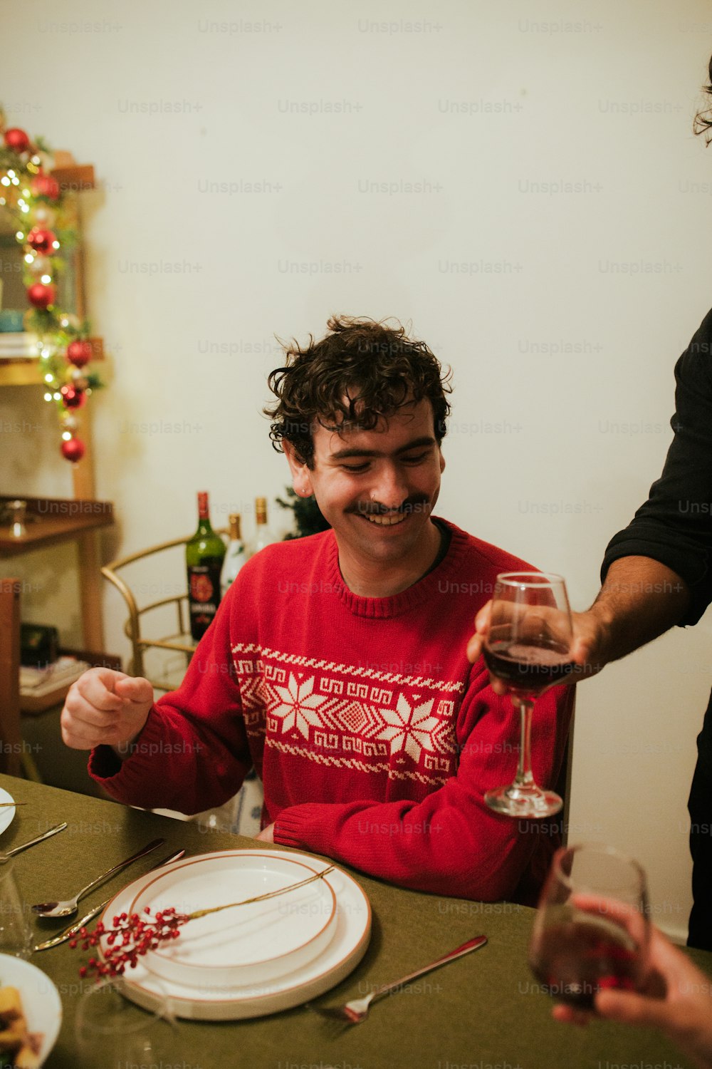 Ein Mann, der mit einem Glas Wein an einem Tisch sitzt