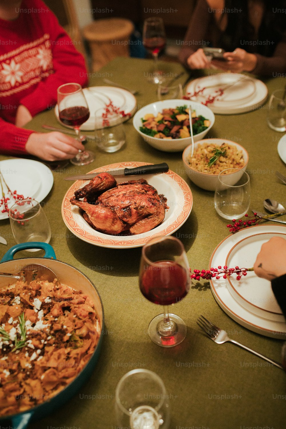 Eine Gruppe von Menschen, die um einen Tisch mit Tellern mit Essen sitzen