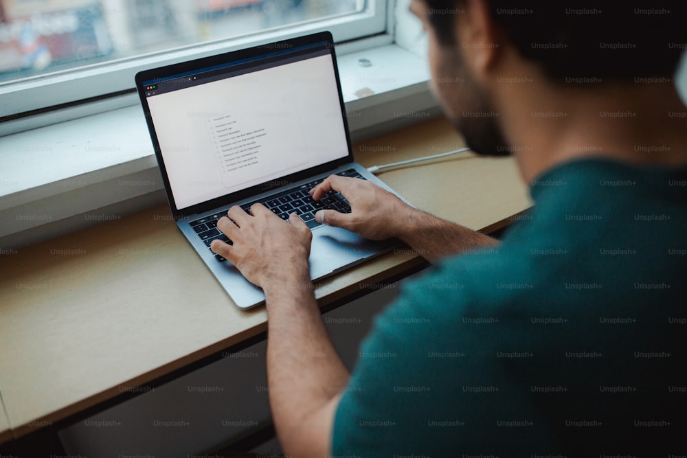 um homem sentado em uma mesa usando um computador portátil