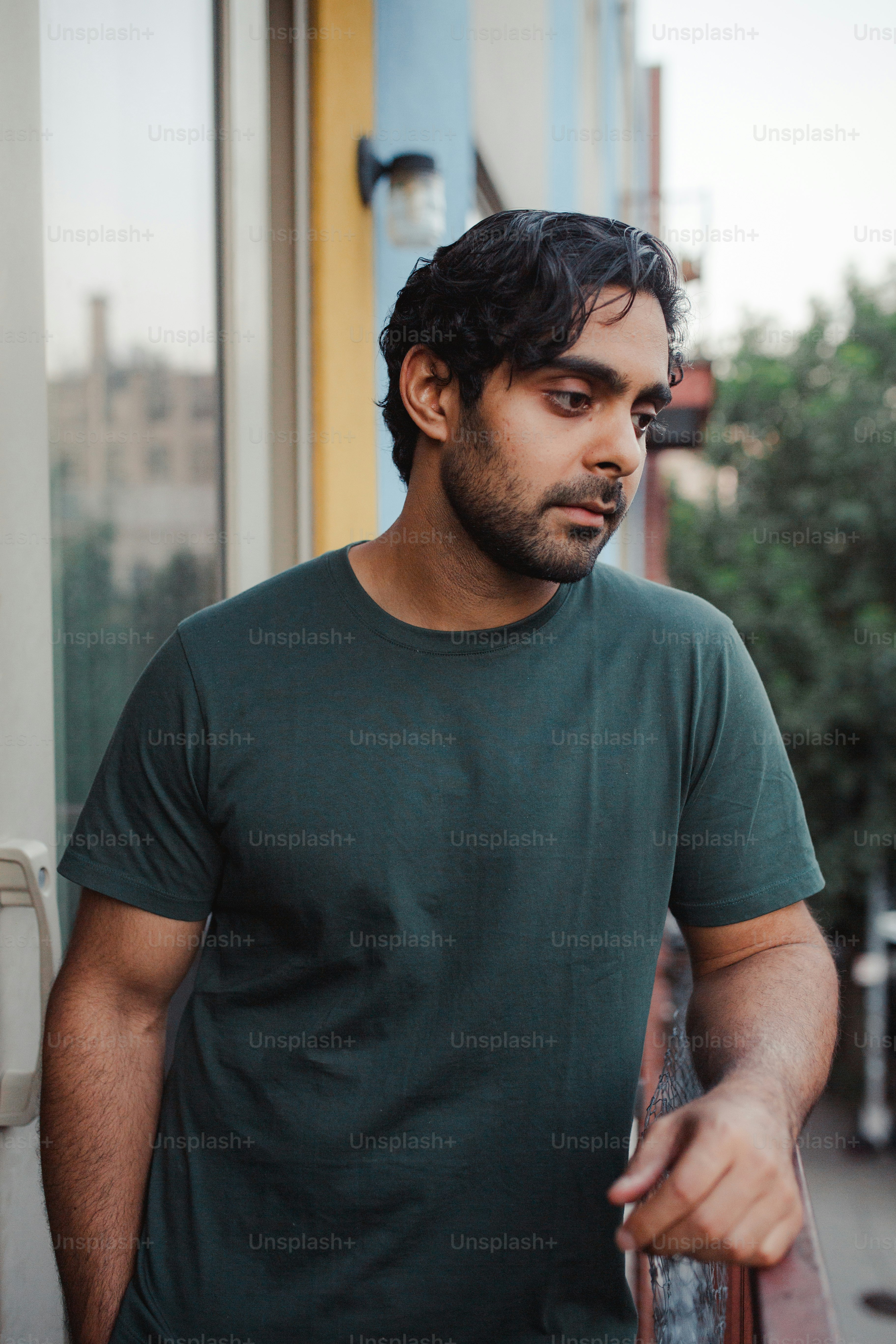 a man in a green shirt is holding a cell phone