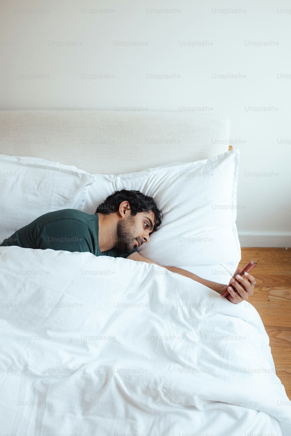 um homem deitado em uma cama com um edredom branco