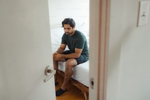 a man sitting on top of a bed in a room