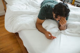 a man laying on a bed with a white comforter