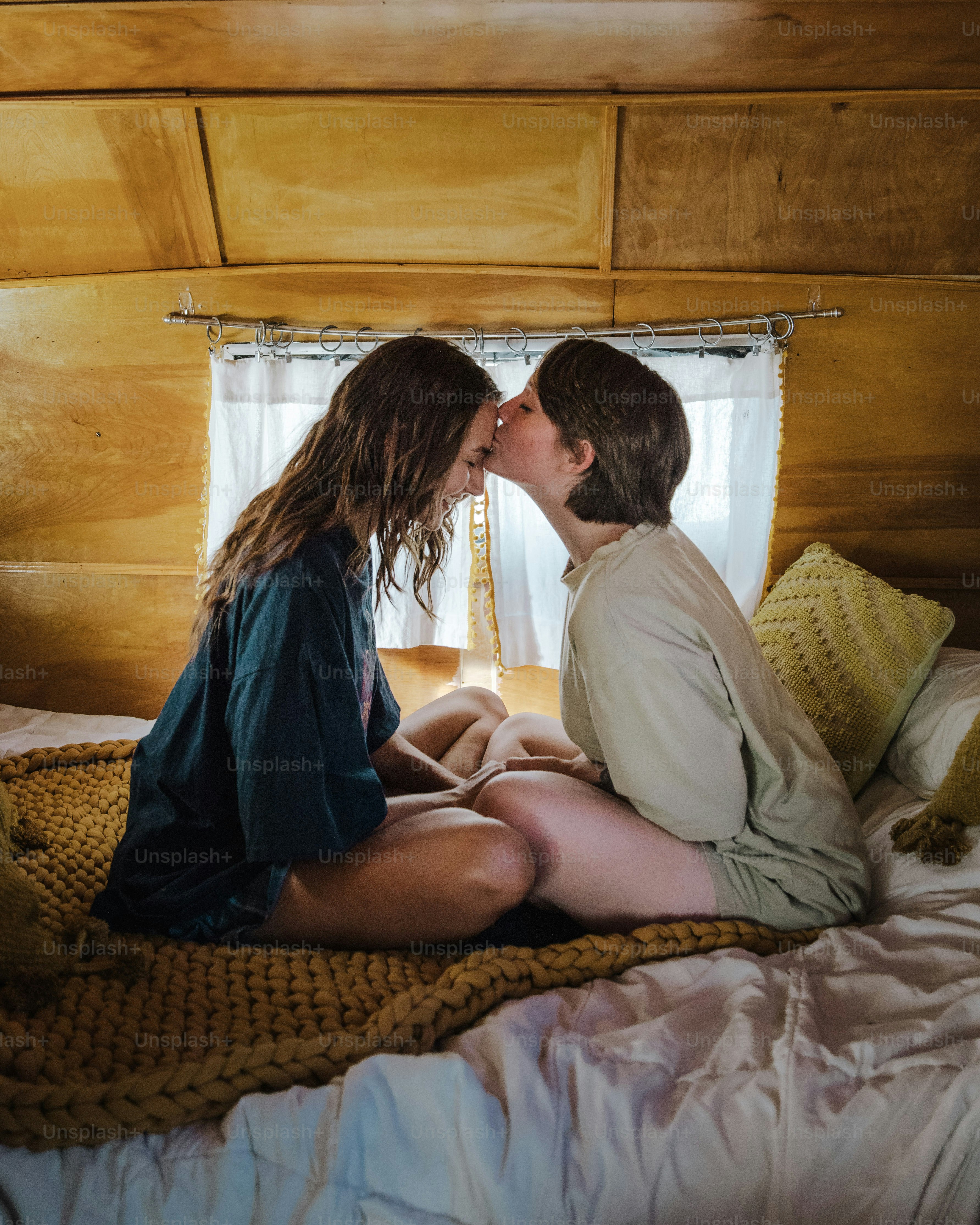 a couple of people that are sitting on a bed