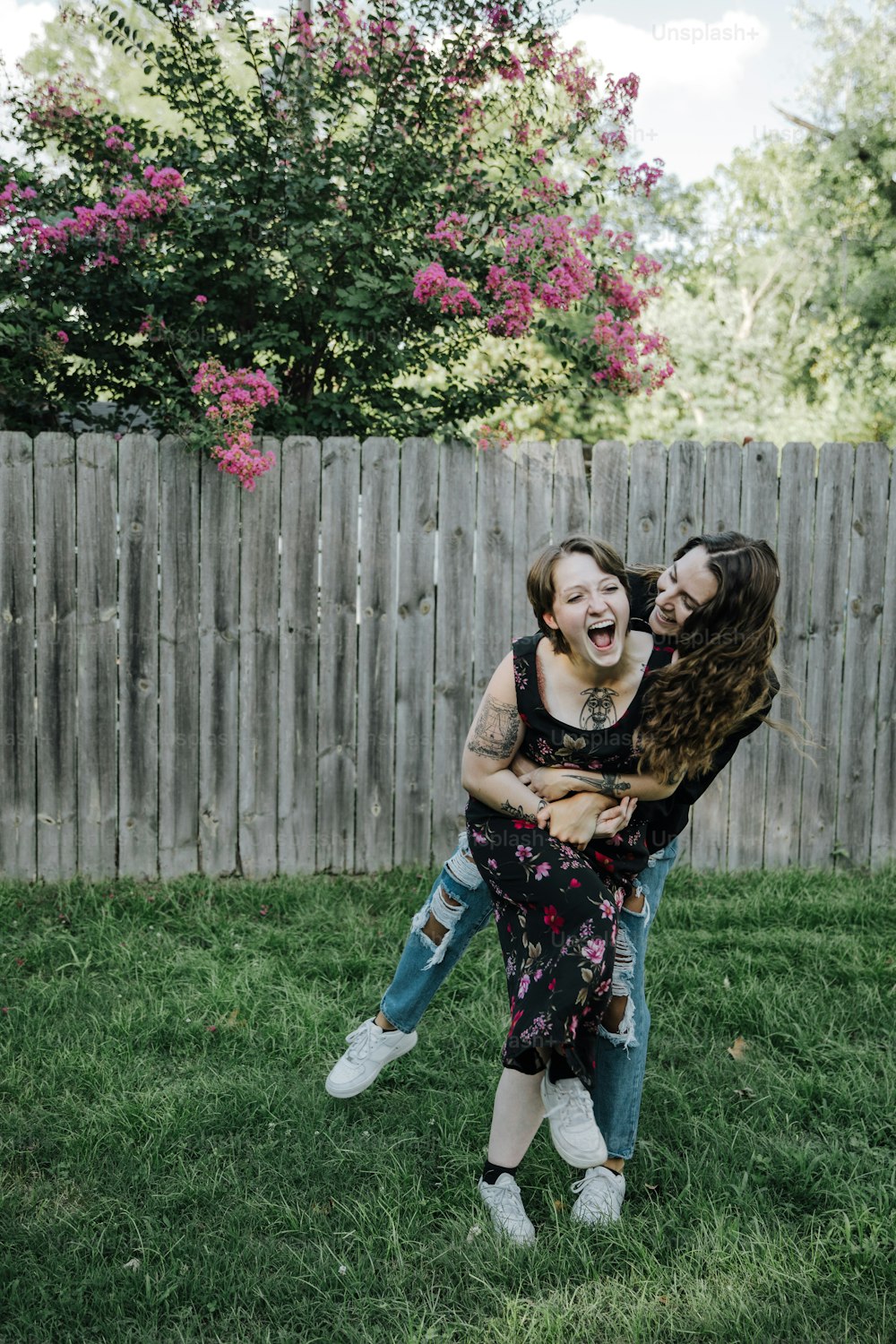 two young women are playing in the grass