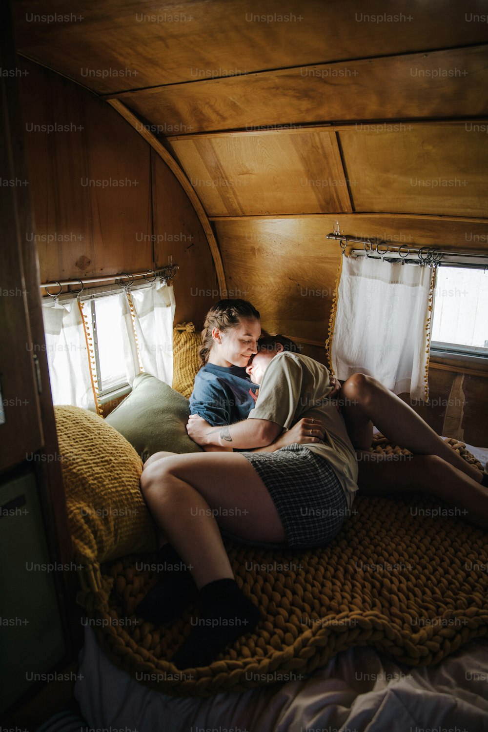 a man and a woman cuddling on a bed