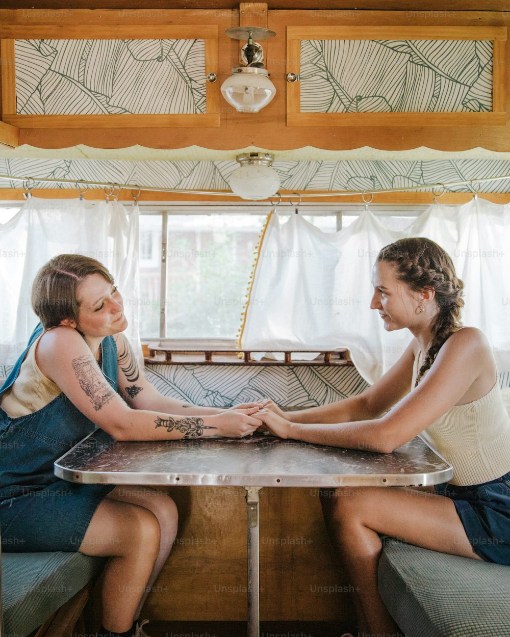 Una coppia di donne sedute a un tavolo davanti a una finestra