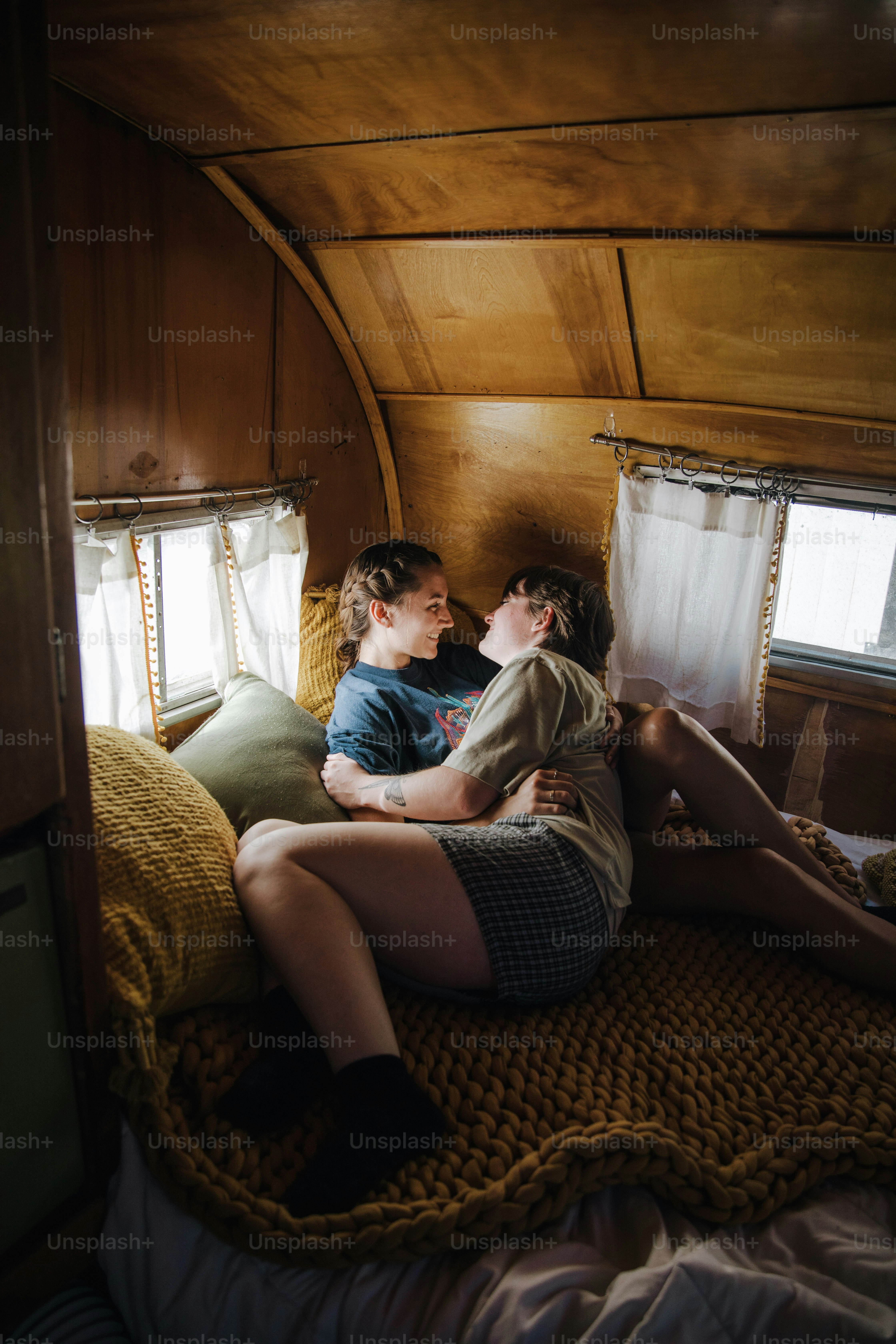 a couple of women sitting on top of a bed