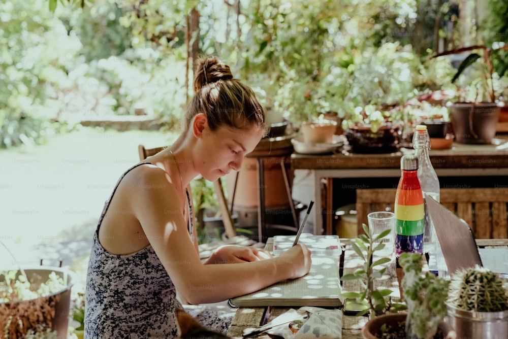 a woman sitting at a table working on a laptop